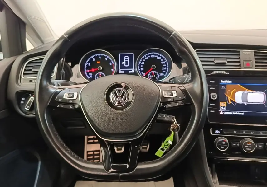 Vue intérieure centrée sur le volant cuir multifonctions d'une Volkswagen Golf 2020 avec tableau de bord et écran tactile.
