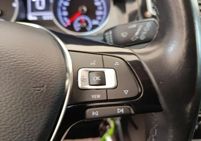 Gros plan sur le volant cuir multifonctions côté gauche d’une Volkswagen Golf 2020 avec commandes intégrées.