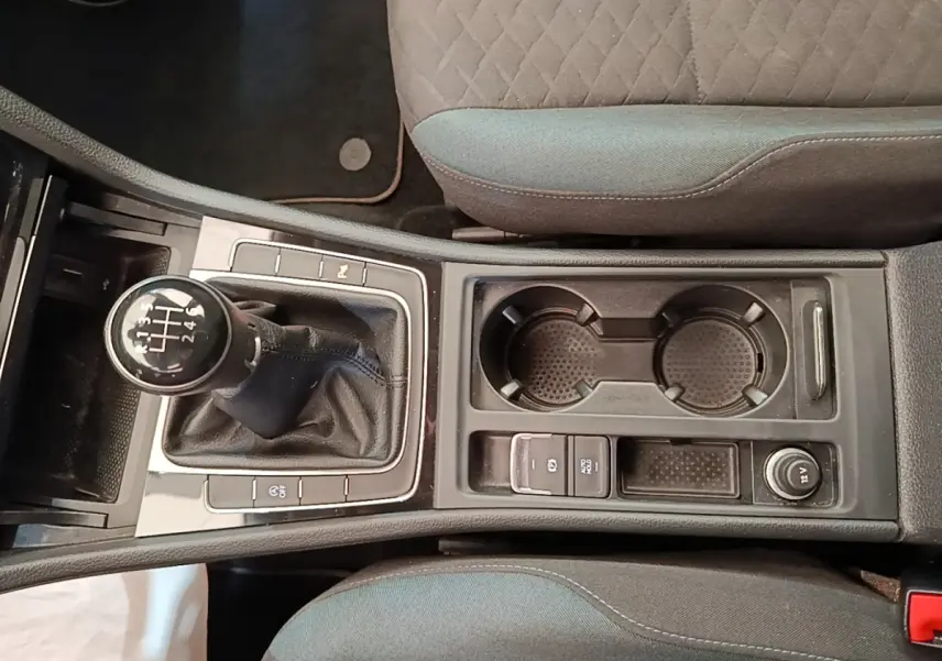 Vue plongeante sur la console centrale de la Volkswagen Golf 1.0 TSI 115 BVM6 avec levier de vitesse manuel et porte-gobelets.