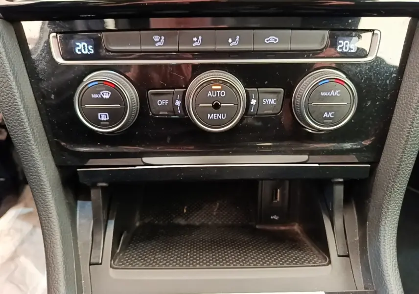 Vue rapprochée de la console centrale de la Volkswagen Golf 2020, avec commandes de climatisation digitales affichant 20,5°C.