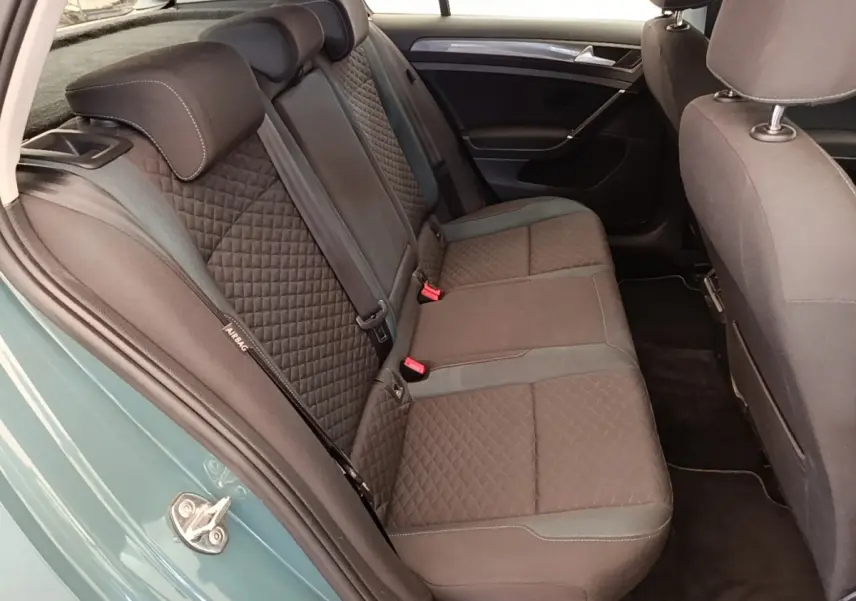 Vue intérieure côté gauche sur la banquette arrière en tissu noir de la Volkswagen Golf bleu 2020.