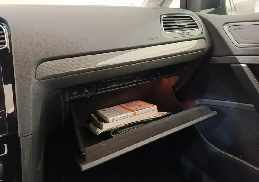Intérieur de la Volkswagen Golf 1.0 TSI 115 BVM6 IQ.DRIVE 2020, vue sur boîte à gants ouverte avec documents visibles.