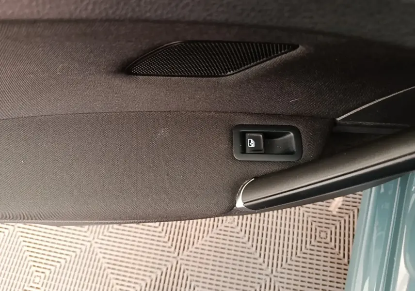 Détail de la poignée intérieure de porte arrière droite d’une Volkswagen Golf bleue, tissu noir et bouton de verrouillage.