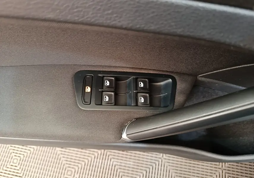 Gros plan sur les commandes des vitres électriques côté conducteur d'une Volkswagen Golf bleu 2020.