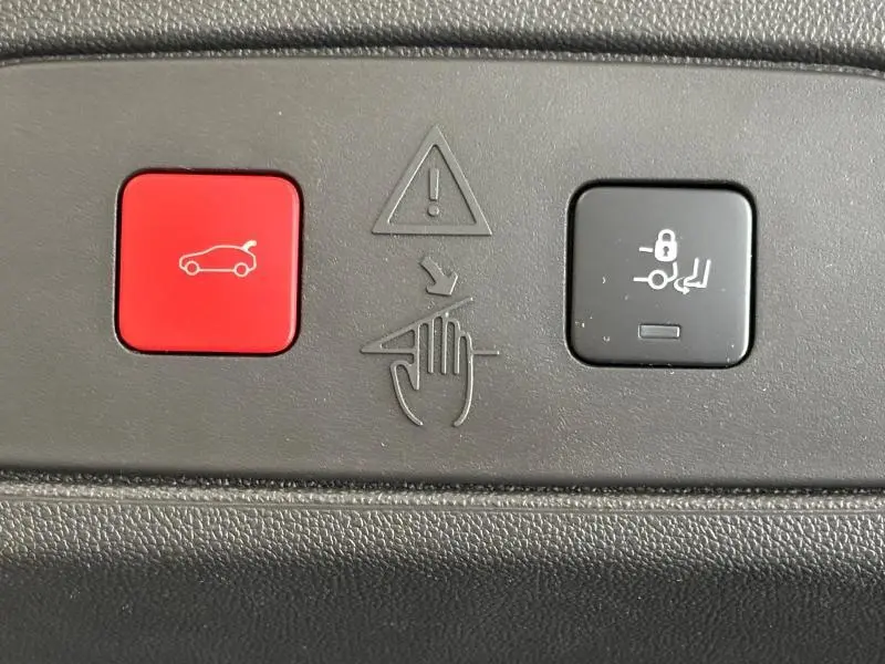 Boutons de commande rouge et noir pour ouverture du coffre et verrouillage des sièges dans un Opel Grandland 2022 noir.