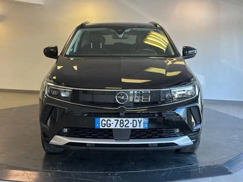 Vue frontale d'un Opel Grandland noir diamant métallisé avec calandre noire et plaques d'immatriculation françaises visibles.
