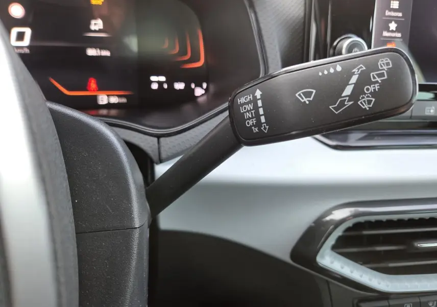 Gros plan sur le commodo d'essuie-glace dans l'habitacle gris clair d'une SEAT Ibiza 2025.