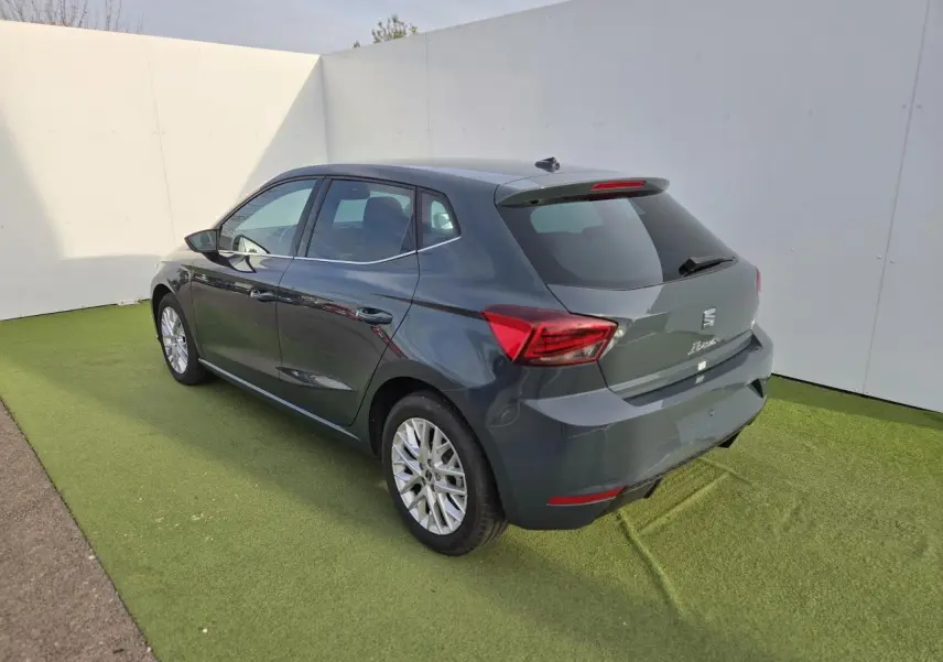 Vue 3/4 arrière droite d'une SEAT Ibiza 2025 bleu fjord métallisé avec jantes alliage et vitres teintées.