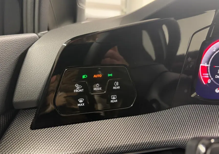 Détail du tableau de bord noir grenadille de la Volkswagen Golf 2.0 TDI 150 DSG7 R-Line avec commandes d’éclairage et mode auto.