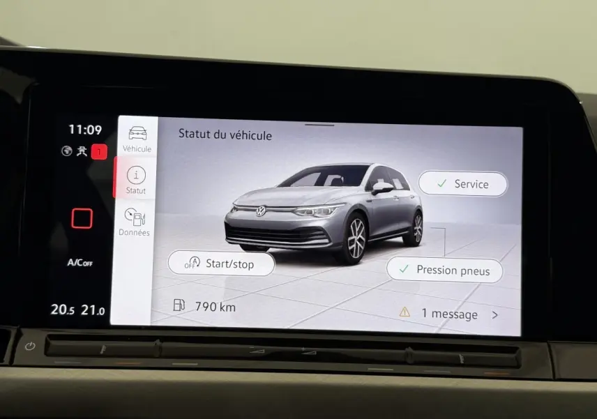 Écran tactile affichant une Volkswagen Golf grise en 3/4 avant avec statut véhicule et options service et pression pneus.