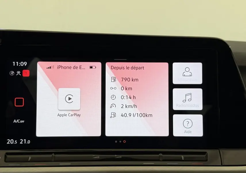 Écran tactile central de la Volkswagen Golf bleu 2021 affichant Apple CarPlay et données de trajet.