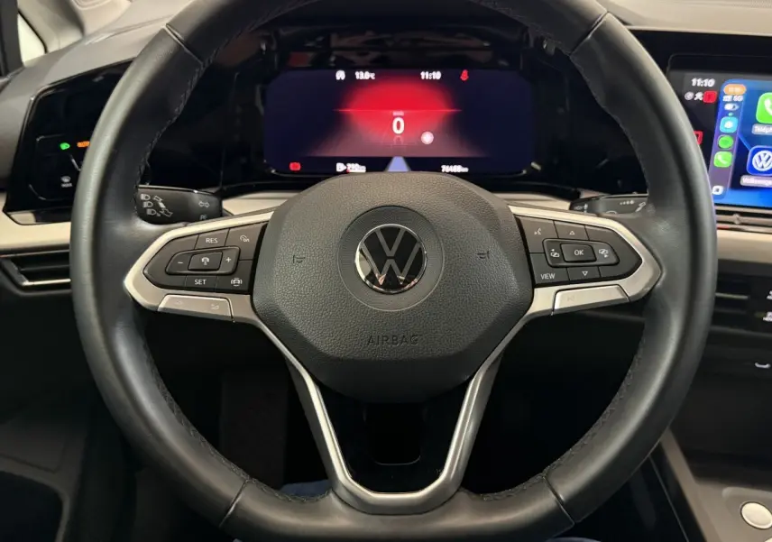 Vue rapprochée du volant cuir multifonctions d’une Volkswagen Golf 2.0 TDI 2021 avec tableau de bord digital et écran tactile.