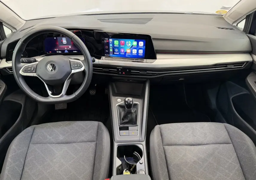 Vue intérieure avant de la Volkswagen Golf 2.0 TDI bleue, avec tableau de bord numérique et boîte manuelle.