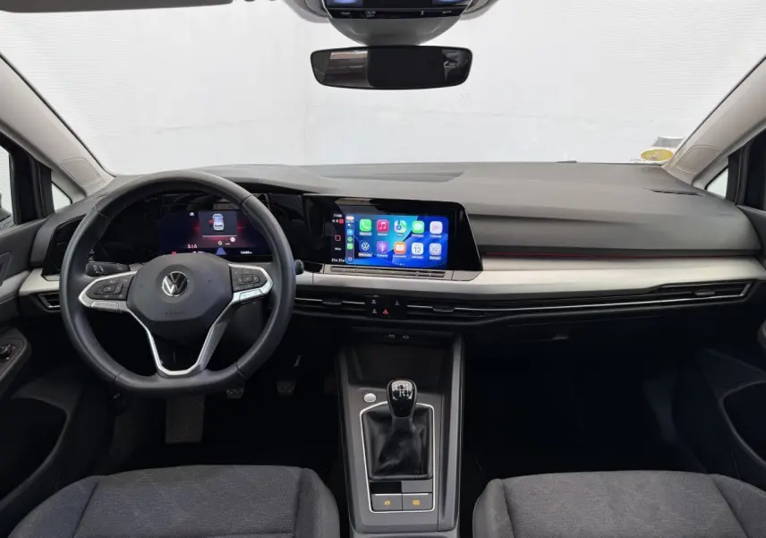 Vue frontale de l'intérieur de la Volkswagen Golf 2.0 TDI Life 2021 avec tableau de bord noir, écran tactile et volant cuir.
