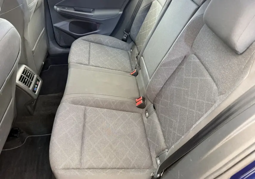Vue côté droit de la banquette arrière grise à motifs de la Volkswagen Golf 2.0 TDI Life avec aérateurs et ceintures visibles.