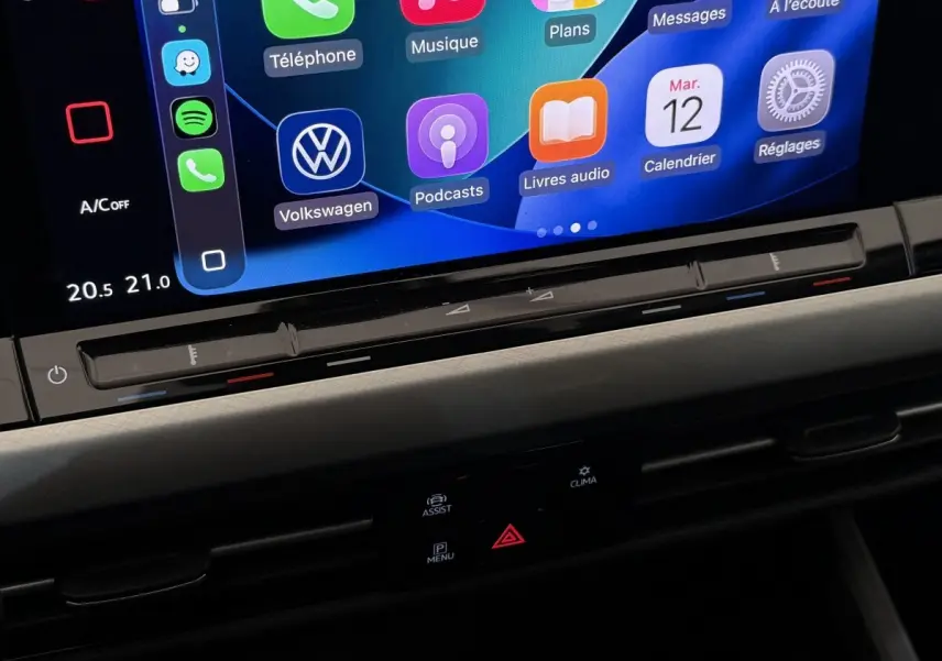 Détail de l’écran tactile central avec commandes climatisation et interface Apple CarPlay dans Volkswagen Golf bleu 2021.