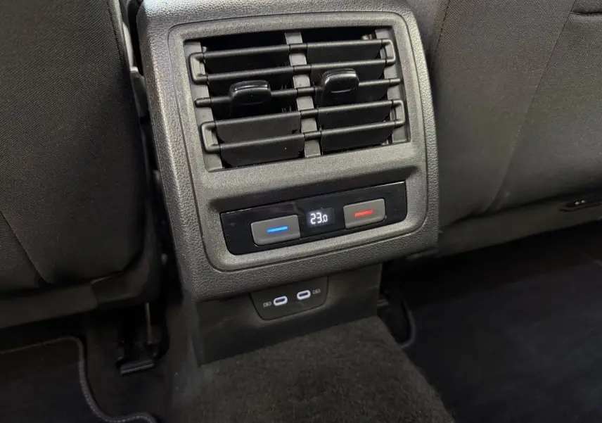Détail des commandes de climatisation arrière et prises USB dans l’habitacle noir d’une Volkswagen Golf bleue.