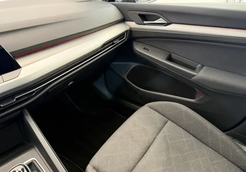 Vue intérieure côté passager de la Volkswagen Golf 2.0 TDI Life 2021 avec tableau de bord noir et siège tissu gris.