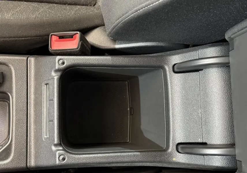 Vide-poche central et frein à main manuel dans l'habitacle d'une Volkswagen Golf 2.0 TDI bleu, vue rapprochée intérieure.