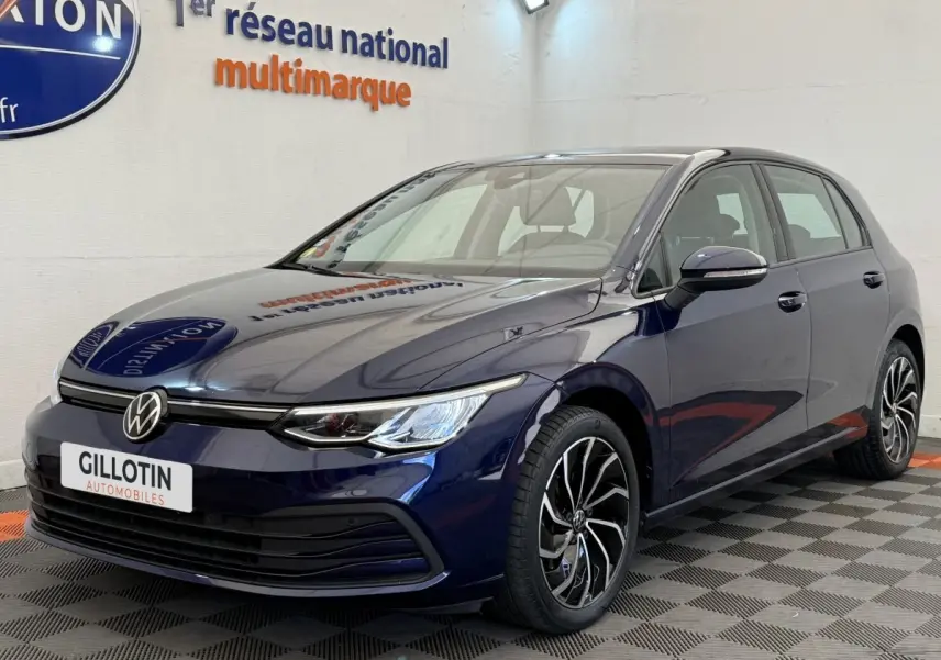 Volkswagen Golf 2.0 TDI bleu en 3/4 avant droit, avec jantes alliage et phares LED allumés.