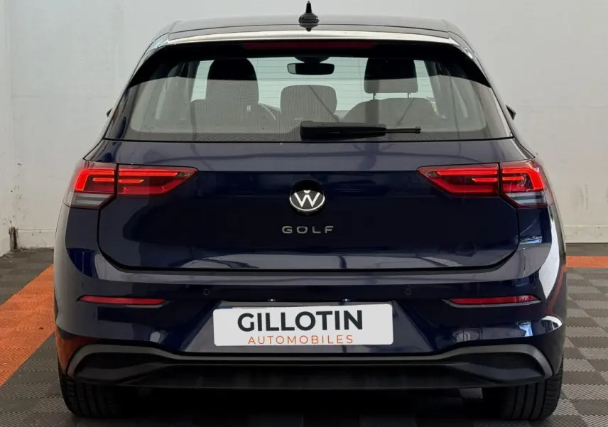 Vue arrière d'une Volkswagen Golf bleu foncé avec feux LED et logo centré sur fond blanc.