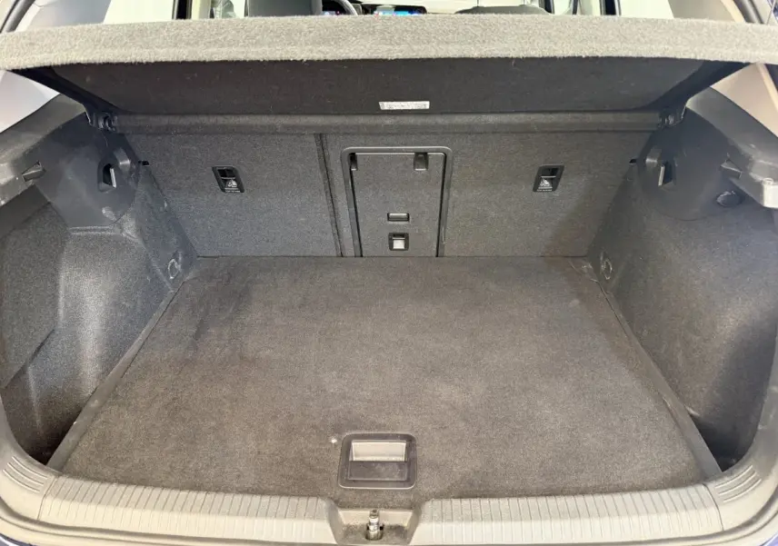 Coffre ouvert de la Volkswagen Golf bleu, vue de l'arrière montrant un espace de chargement propre et spacieux.