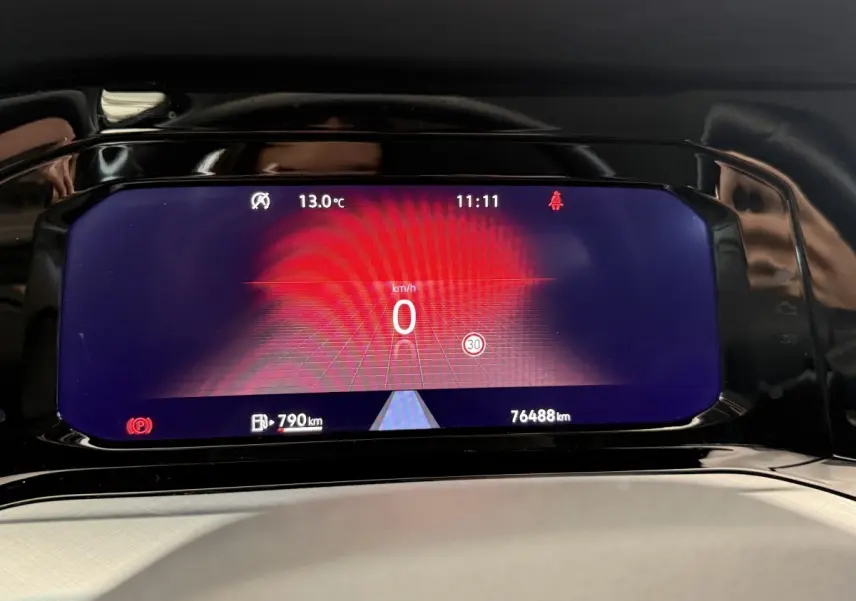 Affichage numérique du tableau de bord de la Volkswagen Golf bleu, montrant la vitesse à 0 km/h et l'autonomie restante.