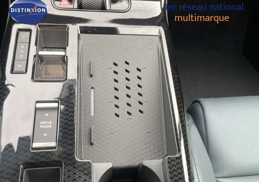 Vue rapprochée de la console centrale noire brillante du Citroën C5 Aircross avec commandes de boîte auto et zone de recharge sans fil.