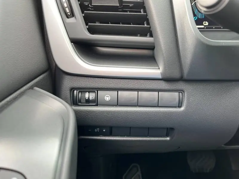 Détail des commandes d'éclairage et assistance au volant à gauche du tableau de bord du Nissan Qashqai e-POWER noir 2024.