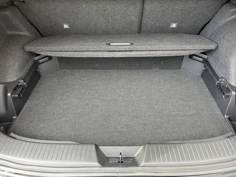 Coffre spacieux du Nissan Qashqai e-POWER 2024, vue intérieure sur le plancher et cache-bagages gris foncé.