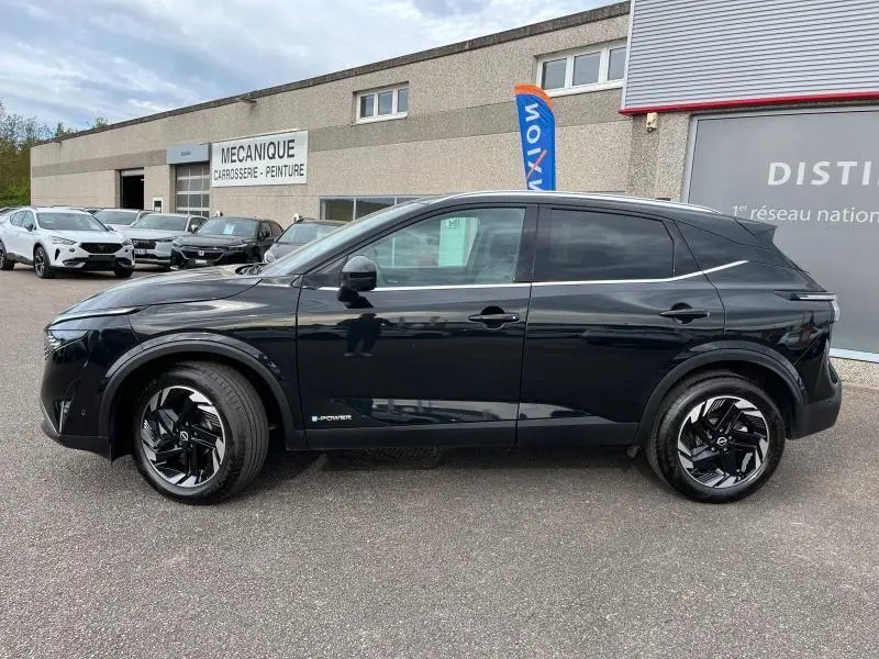Profil côté gauche du Nissan Qashqai e-POWER 2024 noir Kuro métallisé avec jantes alliage noires et vitres teintées.