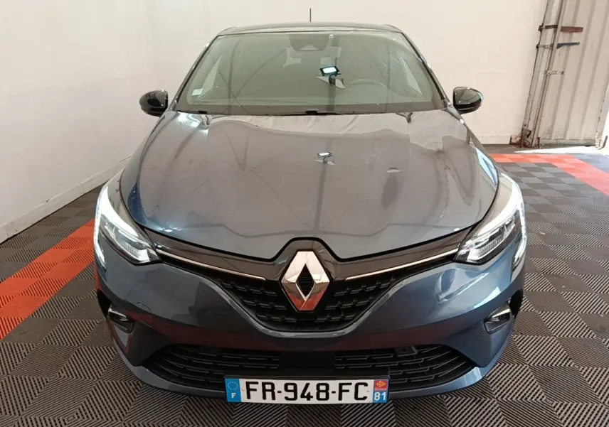 Vue avant d'une Renault Clio Intens TCe 100 gris foncé avec phares LED allumés dans un garage.