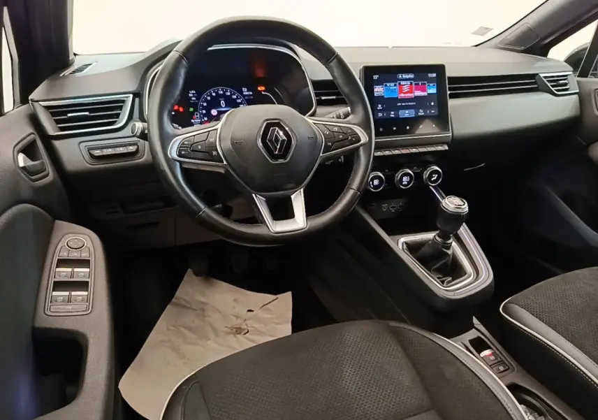 Vue intérieure avant de la Renault Clio Intens 2020, volant cuir, écran tactile 7 pouces et levier de vitesse manuel.