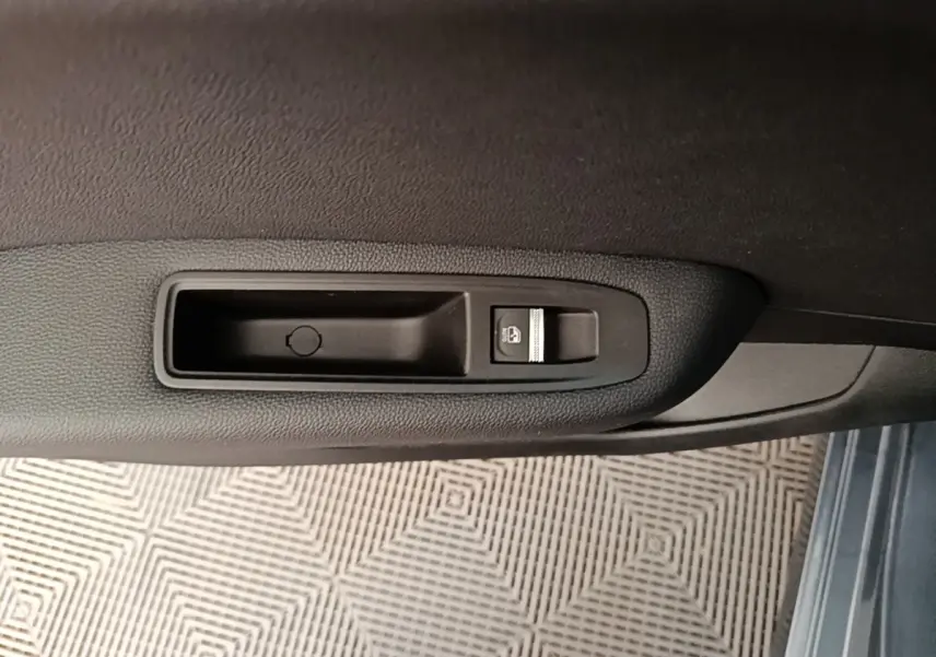 Détail de la commande de lève-vitre électrique sur la porte côté conducteur d’une Renault Clio Intens gris foncé 2020.