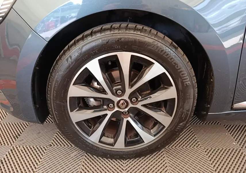 Gros plan sur la roue avant droite gris foncé d'une Renault Clio Intens TCe 100 avec jante alliage bicolore.
