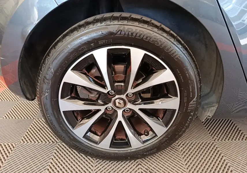 Gros plan sur la roue avant droite de la Renault Clio Intens TCe 100 gris foncé avec jante alliage bicolore.