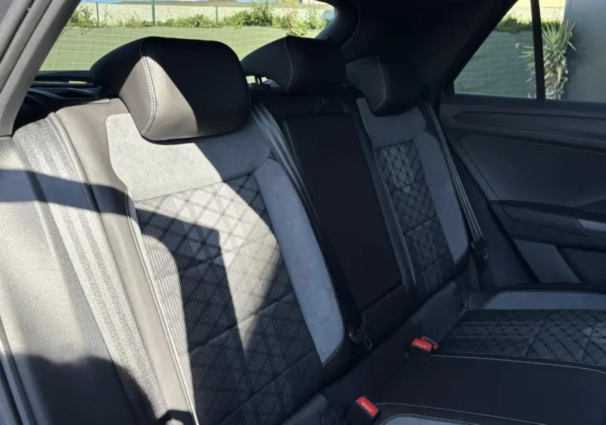 Vue intérieure des sièges arrière en tissu et cuir noir avec surpiqûres blanches du Volkswagen T-Roc gris Indium 2025 R-Line