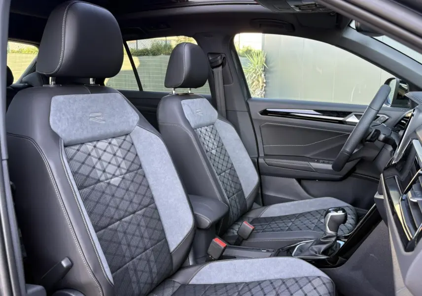 Vue intérieure côté droit du Volkswagen T-Roc 2.0 TDI R-Line 2025, sièges sport gris avec logo R brodé.