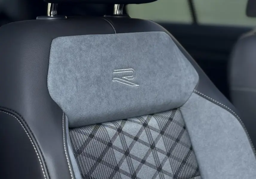 Gros plan sur le siège avant gris et noir du Volkswagen T-Roc 2.0 TDI R-Line avec logo R brodé sur l'appuie-tête