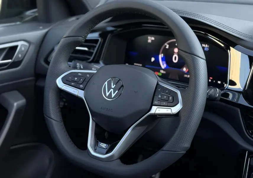 Volant sport multifonction en cuir avec logo R-Line de la Volkswagen T-Roc 2025, vue rapprochée côté conducteur.