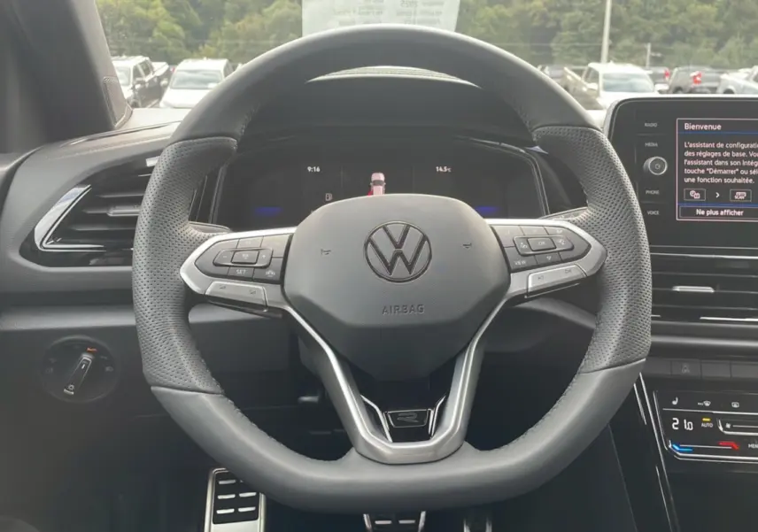 Vue rapprochée du volant multifonction du Volkswagen T-Roc noir grenadilla, version R-Line Black 2025, avec tableau de bord digital.