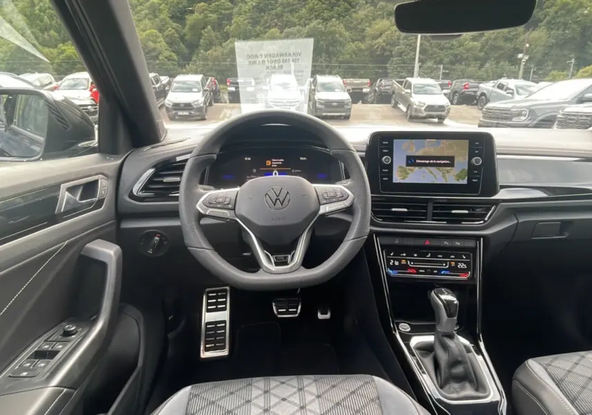 Vue intérieure centrée sur le volant et la console du Volkswagen T-Roc noir grenadilla 2025, finition R-Line Black.