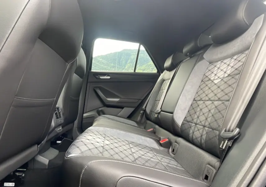 Vue intérieure arrière du Volkswagen T-Roc 2025, sièges arrière en cuir noir et tissu gris à motif losange.