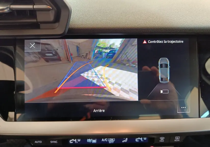 Écran tactile intérieur montrant la caméra de recul avec guidage dynamique sur Audi A3 noire, vue arrière.