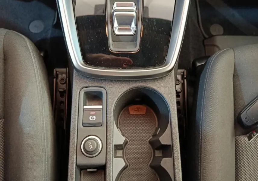 Vue plongeante sur la console centrale noire de l'Audi A3 30 TFSI MHEV avec boîte auto et porte-gobelets intégrés.
