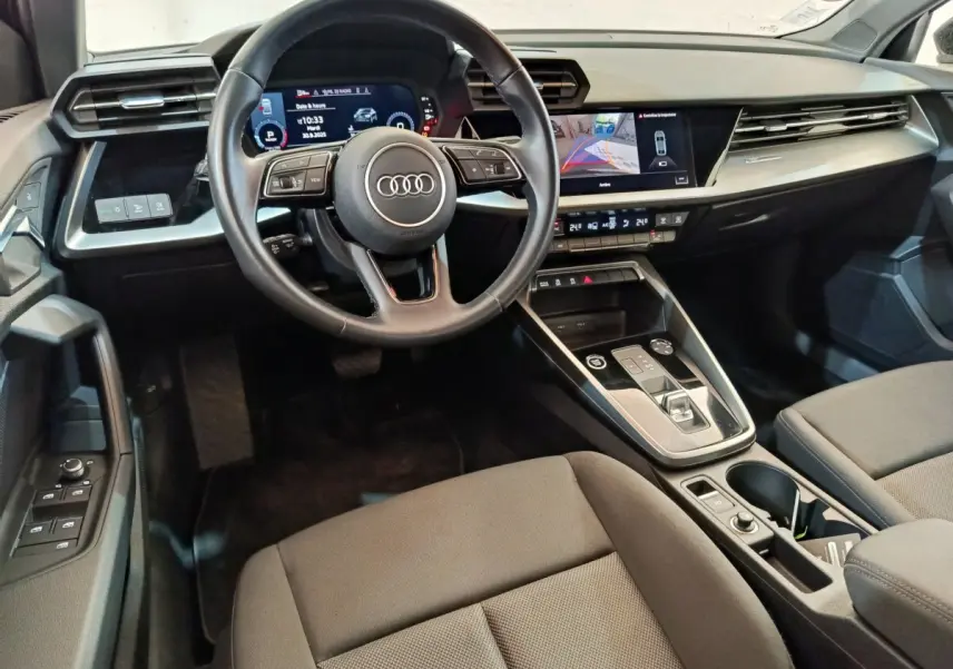 Intérieur noir de l'Audi A3 2022 vu côté conducteur, avec tableau de bord digital et écran tactile central.