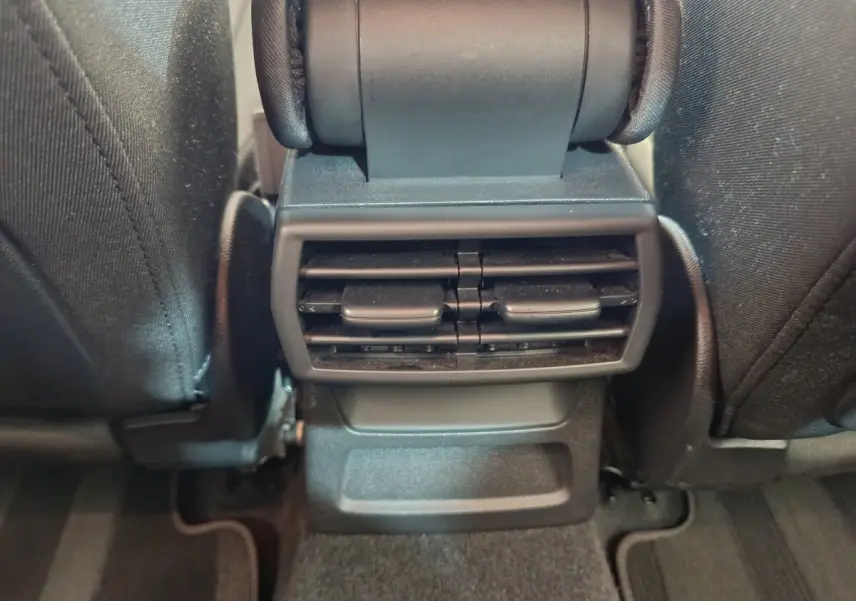 Vue rapprochée des aérateurs arrière noirs entre les sièges avant d'une Audi A3 30 TFSI MHEV Business Line 2022.