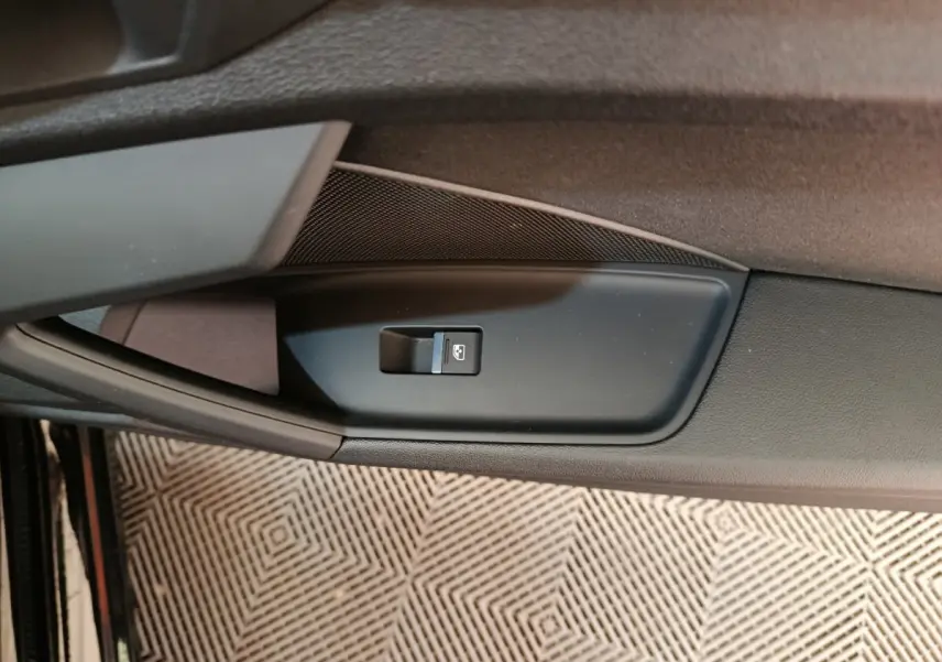 Détail de la commande de lève-vitre côté conducteur sur la porte intérieure noire d'une Audi A3 2022.