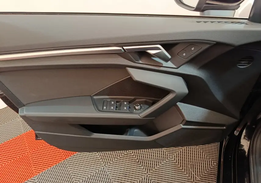 Panneau de porte côté conducteur noir de l'Audi A3 30 TFSI MHEV 2022 avec commandes électriques et verrouillage.