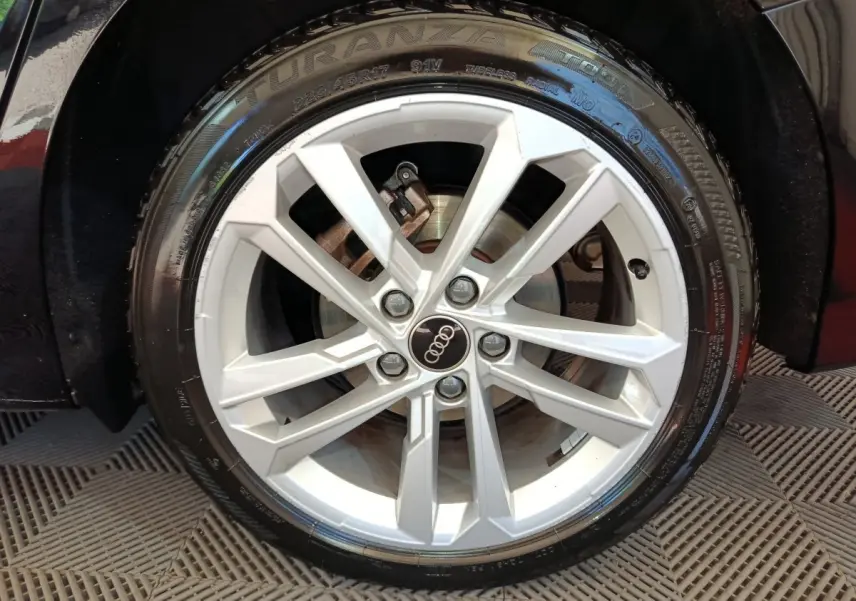 Gros plan sur la roue avant droite noire d'une Audi A3 30 TFSI MHEV avec jante argentée à 5 doubles branches.